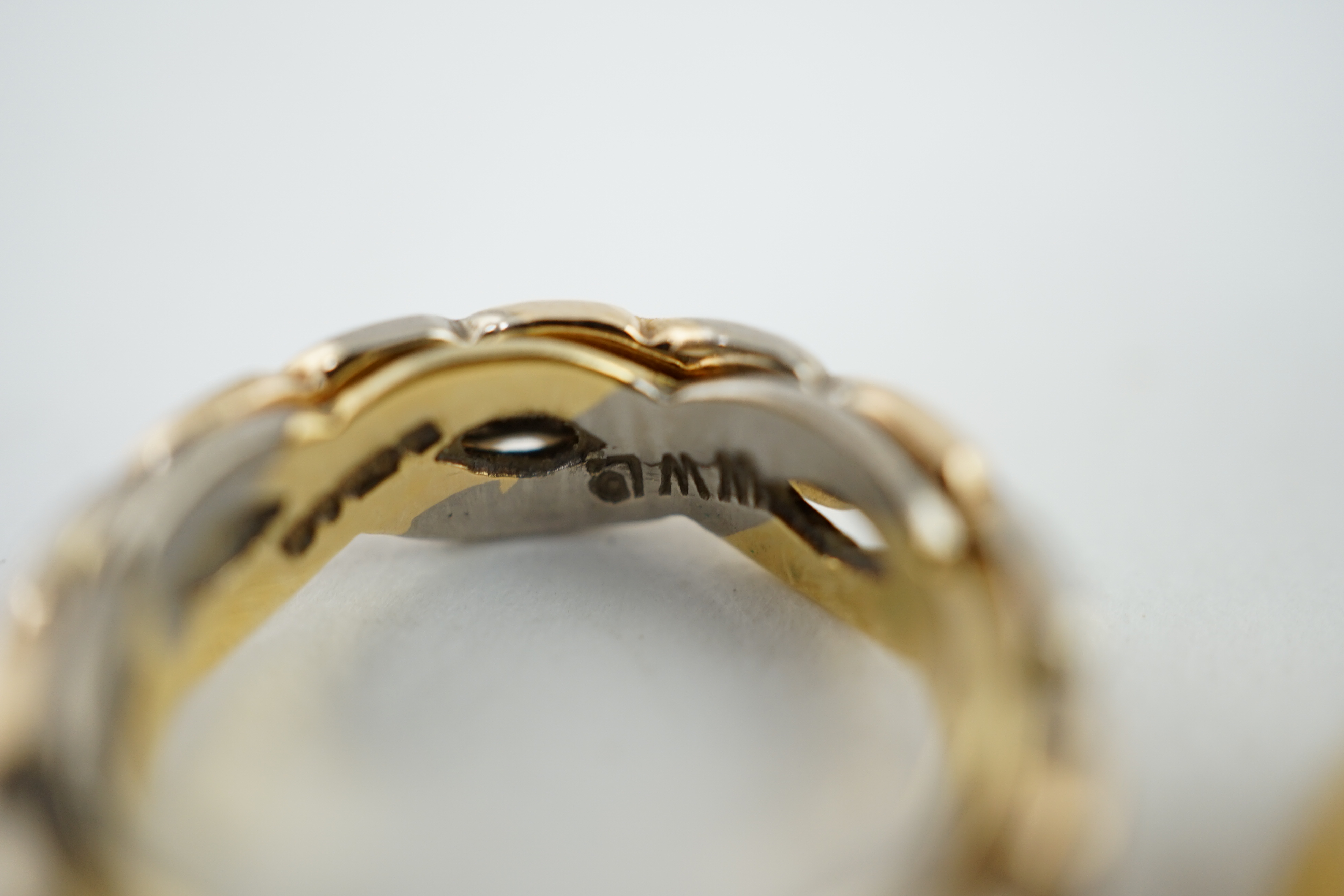 A George V engraved 18ct gold band, size M/N, together with two three or two colour 18ct gold bands